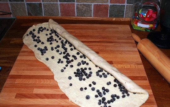 1. Этап. Булочки на живых дрожжах: 7. Тесто раскатайте на рабочем столе, присыпанном мукой. Выложите чернику или любые другие свежие или размороженные ягоды. Аккуратно сверните рулетом.