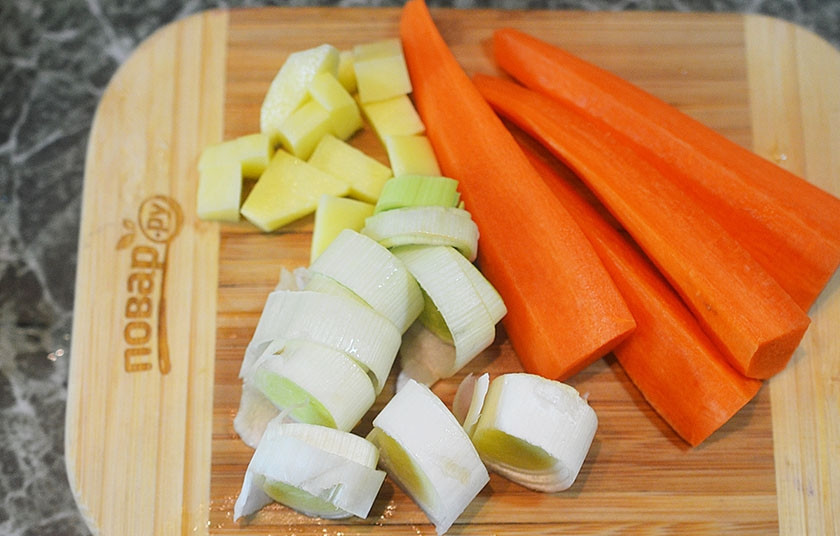 1. Этап. Мясо по-венски (тафельшпиц): 4. Морковь очистите и нарежьте вдоль, сельдерей нарежьте ломтиками, а лук-порей — кольцами.
