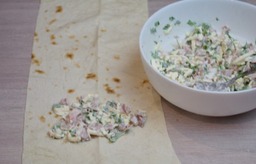 1. Этап. Лаваш в кляре: На край лаваша выложите 2 столовые ложки начинки. Сверните рулетиком-конвертиком. У меня из одной полоски вышло 2 рулетика-конвертика.