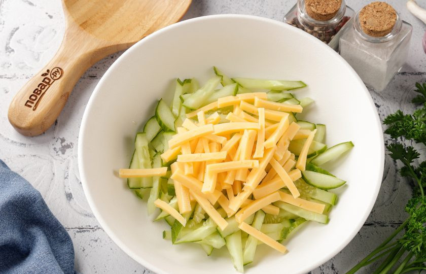 1. Этап. Салат с кукурузой, огурцом и сыром: Добавьте нарезанный примерно такой же соломкой сыр.