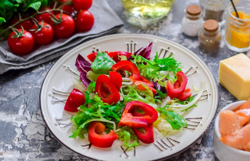 1. Этап. Салат с соленой красной рыбой: Болгарский перец очистите и сполосните, нарежьте средними кусочками и выложите поверх салата.