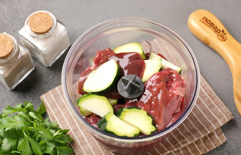 1. Этап. Закусочный печёночный торт с кабачками: Печень промойте, обсушите, если необходимо нарежьте кусочками и переложите в чашу блендера. Добавьте нарезанный кабачок. Если кабачок зрелый, то предварительно снимите шкурку и удалите семена.