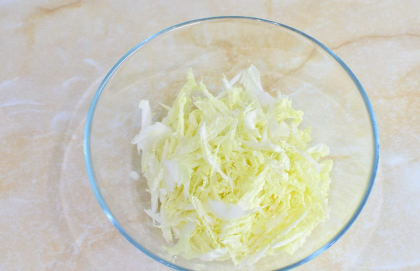 1. Этап. Салат с ананасом, креветками и пекинской капустой: Пекинскую капусту тонко нашинкуйте и выложите в салатник.