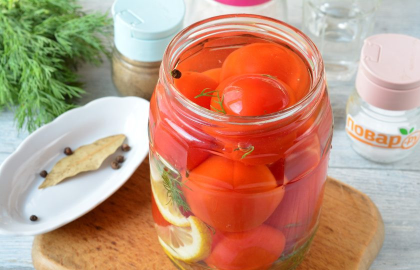 1. Этап. Маринованные помидоры с лимоном на зиму: Вскипятите воду и влейте в банки с помидорами. Оставьте на 10-15 минут.