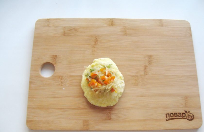 1. Этап. Жареные картофельные пирожки с квашеной капустой: Из порции теста сделайте лепешку и выложите на неё начинку.