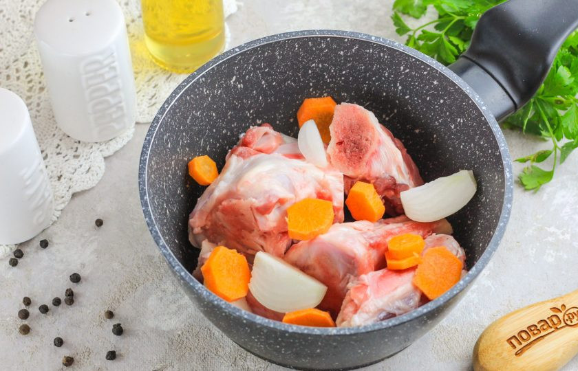 1. Этап. Бульон на сахарной кости: Кости промойте в воде и выложите в казан, ковш или кастрюлю с антипригарным дном. Нарежьте крупными кубиками или ломтиками морковь и луковицы, также добавьте в емкость. Овощи добавляются в бульон для придания вкуса и цвета ему, а не для того, чтобы наполнить блюдо витаминами. Поэтому их варят с самого начала приготовления.