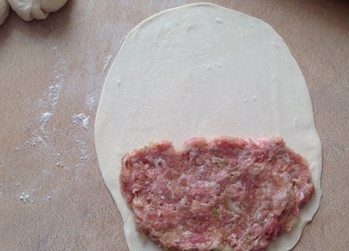 1. Этап. Чебуреки из слоеного теста: Раскатываем кусочек теста в лепешку толщиной примерно 2-3 мм. Выкладываем на одну половину лепешки фарш, распределяем его ровным слоем.