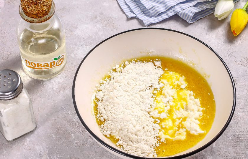 1. Этап. Творожное печенье с клюквой: Выложите во взбитую массу творог любой жирности и всыпьте пшеничную муку по частям. Вмешайте и разрыхлитель.