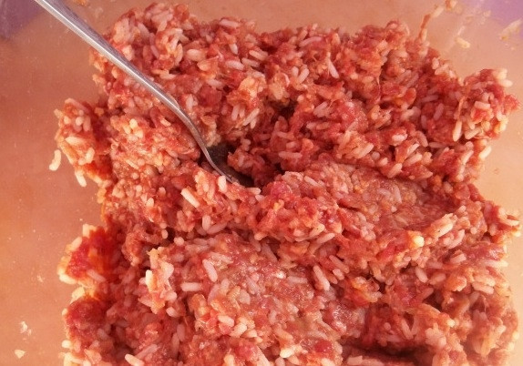 1. Этап. Долма по-грузински: Готовим начинку. Для этого смешиваем фарш, отваренный до полуготовности рис, прокрученные через мясорубку лук и чеснок, а также специи. Перемешиваем до однородности.