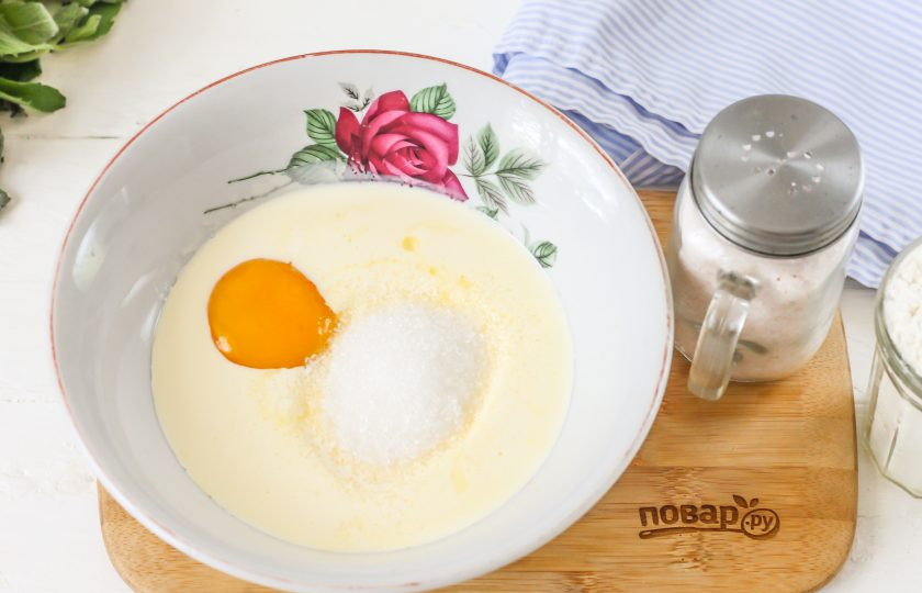 1. Этап. Пирог с персиковым вареньем: Сливочное масло растопите на водяной бане или в микроволновке. Слегка остудите и всыпьте в него сахар, соль. Отделите белок от желтка, разбив куриное яйцо, выложите в масло желток. Белок вам не потребуется в рецепте.