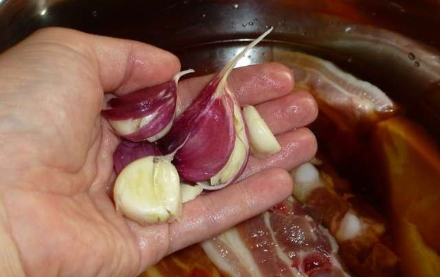 1. Этап. Свиные ребрышки в соевом соусе: Теперь берем зубчики чеснока (чистить их не надо) и аккуратно раздавливаем их ножом, отправляем в кастрюлю.