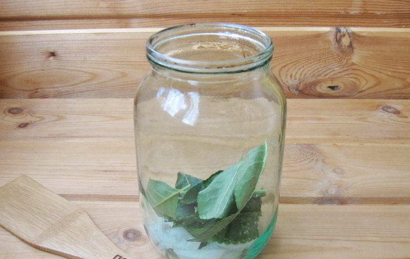 1. Этап. Помидоры на зиму с уксусом: Листья хрена и вишни помойте и добавьте в банки.