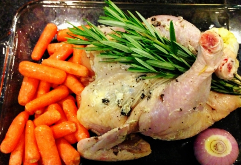 1. Этап. Курица в духовке на Новый год: 1. За час до выпечки присыпьте курицу (внутри и снаружи) солью и положите в холодильник. Вытащите, промокните бумажным полотенцем выступившую жидкость. Смажьте курицу маслом, поперчите, выложите в смазанную растительным маслом форму. Выложите рядом промытую морковь и целую головку чеснока со срезанной верхушкой. Пучок розмарина положите на курицу.