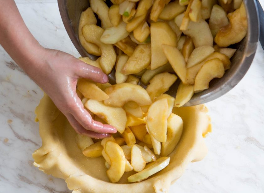 1. Этап. Пирог с ароматными яблоками: Форму для выпекания смазываем сливочным маслом, выкладываем раскатанный пласт теста. Сверху распределяем начинку из яблок.