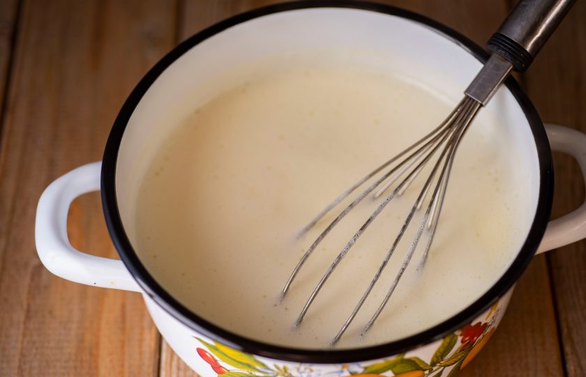 1. Этап. Молочное мороженое с клубникой: Затем смесь из миски тонкой струйкой залейте в кастрюлю к горячему молоку, при этом активно и постоянно мешайте венчиком, чтобы яичные желтки не успели свернуться. На небольшом огне варите смесь, постоянно помешивая венчиком, до закипания и легкого, но заметного загустевания. Как только смесь станет по консистенции подобна сгущенному молоку, кастрюлю снимайте с плиты. Охладите смесь до комнатной температуры.