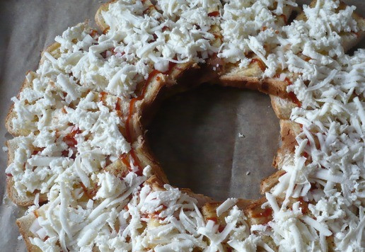 1. Этап. А-ля пицца с колбасой Индилайт: На крупной терке натрите 150 грамм моцареллы и также присыпьте кусочки хлеба.