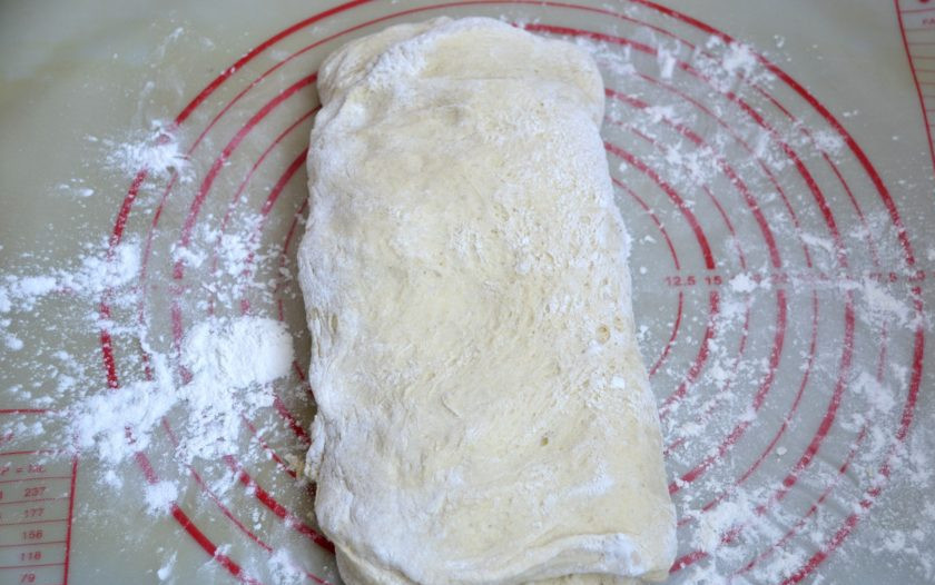 1. Этап. Кукурузный хлеб на дрожжах: Распрямите пласт теста и сложите конвертом, сначала встречно две стороны.