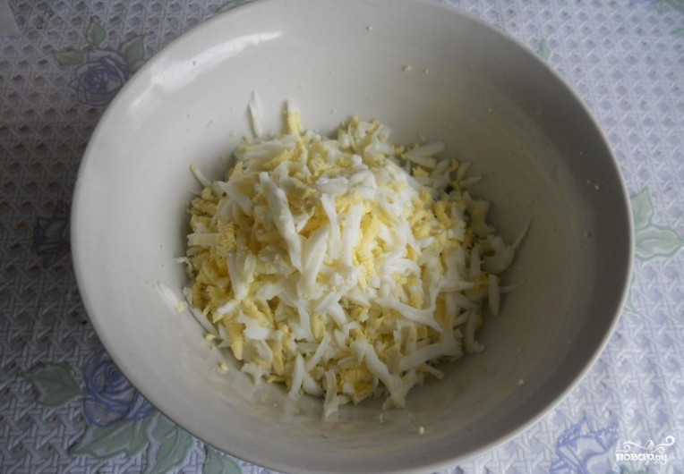 1. Этап. Сырный салат с чесноком: Отварные яйца очищаем и трем на терке. Добавляем к чесноку.