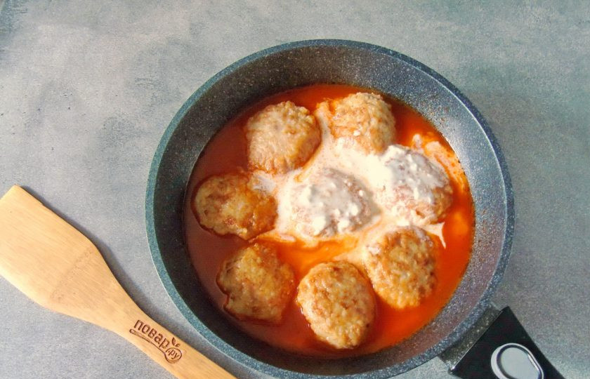 1. Этап. Тефтели с рисом как в детском саду: 1 столовую ложку муки разведите со сметаной в стакане теплой воды. Хорошо перемешайте, комочков не должно быть. Влейте эту смесь в сковороду с тефтелями.