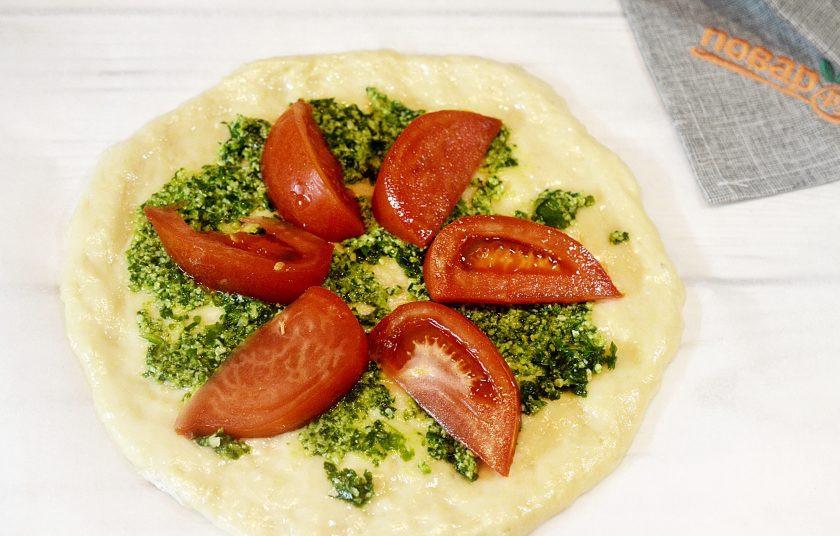 1. Этап. Пицца с сыром из козьего молока и рукколой: 4. Выложите дольки помидора и посыпьте чесноком.