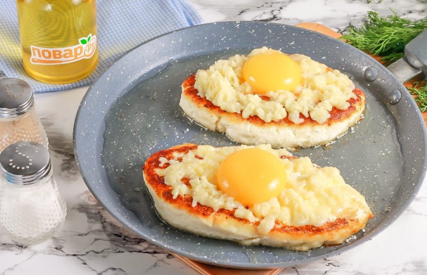 1. Этап. Ленивый творожный хачапури по-аджарски на сковороде: В это время натрите сыр на терке с мелкими ячейками. Переверните хачапури на другую сторону и выложите на поджаренную часть натертый сыр, а в середину — желток. Накройте емкость крышкой и обжарьте еще 2-3 минуты до расплавления сыра и схватывания желтка.