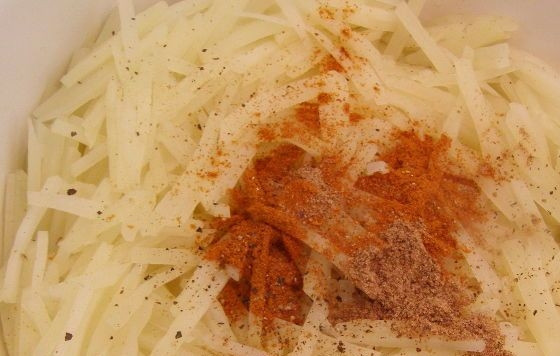 1. Этап. Салат картофельный корейский: К картофелю добавьте чёрный и красный перцы, а также мускатный орех. Хорошо перемешайте ингредиенты.