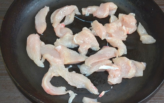 1. Этап. Салат Ревнивец: 2. На сковороду с растительным маслом выложите нарезанное тонкими ломтиками куриное филе. Обжарьте до легкой корочки.