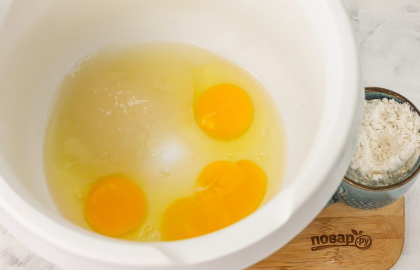 1. Этап. Пирог с яблоками и ягодами: Вбейте куриные яйца в глубокую емкость, всыпьте соль и сахарный песок. Взбейте все в течение 4-5 минут в пышную пену миксером или с помощью кухонного комбайна, но не перевзбейте, иначе пена расслоится.