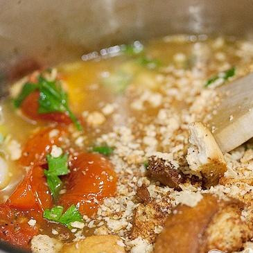 1. Этап. Суп с запеченным чесноком, помидорами и сыром: 6. Добавить измельченный базилик и зелень петрушки, перемешать. Добавить горячий куриный бульон и сухарики, готовить без крышки в течение примерно 20 минут.