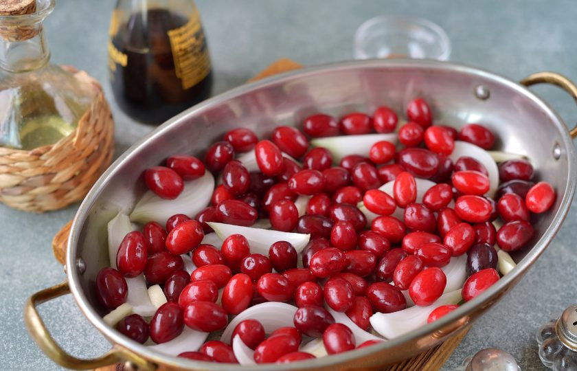 1. Этап. Курица с кизилом в духовке: Кизил тщательно помойте под проточной водой, добавьте в форму, перемешайте с луком.