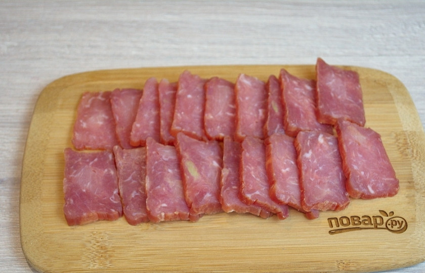 1. Этап. Мясная нарезка в виде ёлочки: Балыковую колбасу нарежьте на кусочки.