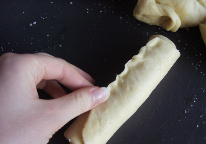 1. Этап. Булочки-сердечки с сахаром: Желательно сахаром чуть не досыпать по краям, иначе тесто может плохо скрепляться. Заворачиваем лепешку, посыпанную сахаром, в рулетик, защипываем края теста.