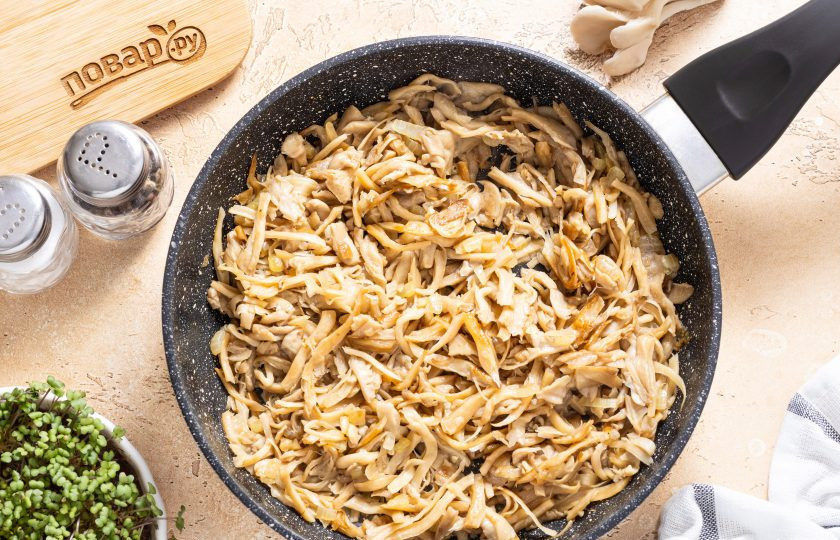 1. Этап. Картофель фаршированный вешенками: Выложите вешенки в сковороду, жарьте на среднем или чуть выше среднего огня. В начале выпарите из грибов всю лишнюю жидкость, затем посолите и поперчите по вкусу. Жарьте вешенки до румяного цвета.