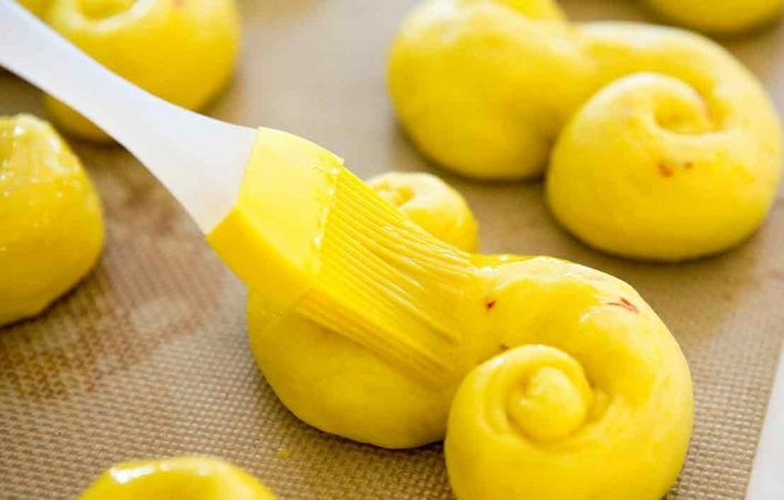 1. Этап. Булочки с шафраном: 13. Оставшееся яйцо размешайте и смажьте им выпечку.