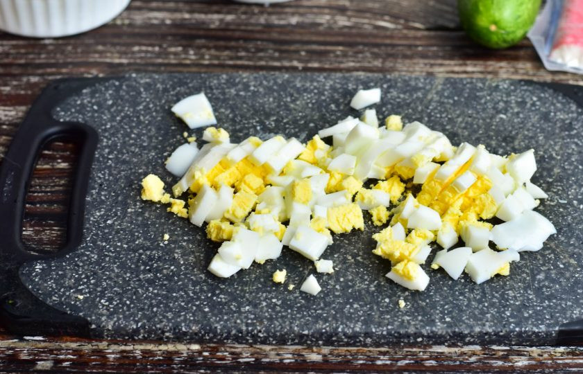 1. Этап. Салат с крабовым мясом по ГОСТу: Куриное яйцо отварите, очистите и нарежьте кубиками.