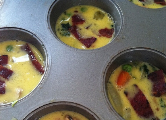 1. Этап. Мини фриттата: 6. Сверху влейте яйца и разложите бекон кусочками, а также петрушку.