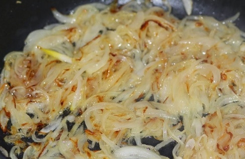 1. Этап. Морской судак в духовке: Репчатый лук чистим от шелухи, нарезаем тонкой соломкой и жарим на растительном масле до золотистого цвета.