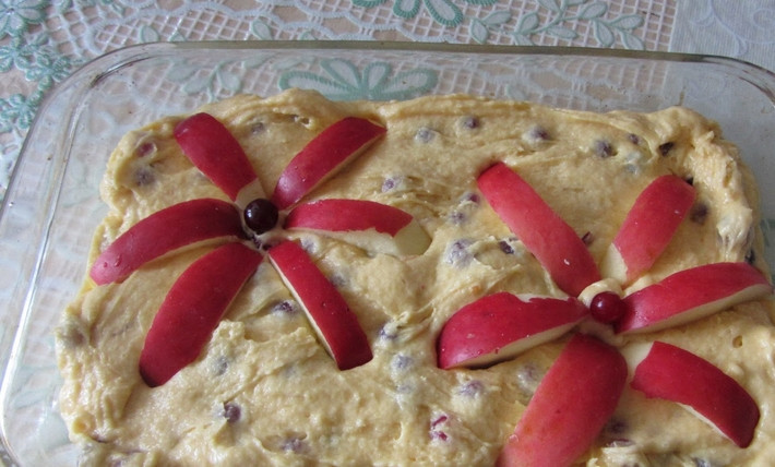 1. Этап. Клюквенный пирог простой: Придаем тесту аккуратную и красивую форму. Яблоко промываем и нарезаем тонкими дольками, украшаем ими пирог.