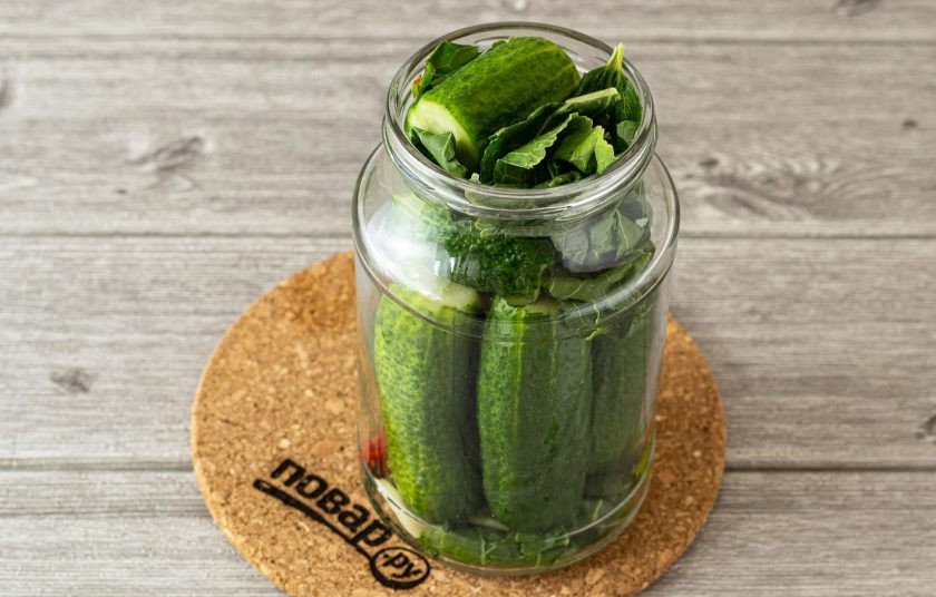 1. Этап. Огурцы на зиму с водкой: Влейте в банку кипяток. Прикройте крышкой. Оставьте так на 15 минут.