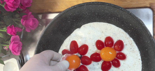 1. Этап. Яичница в форме цветка: Далее выкладываем помидоры и желтки в центр.