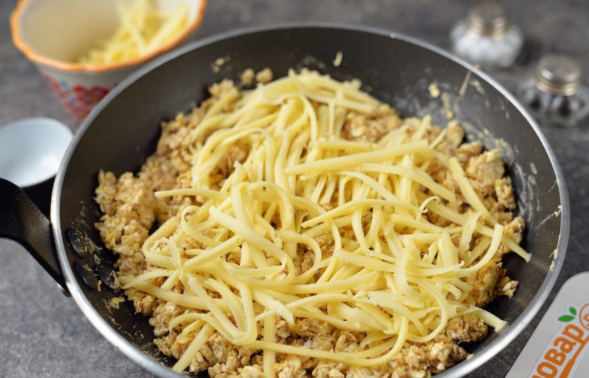 1. Этап. Жареная овсянка с яйцом: Когда все хлопья будут полностью покрыты яичной смесью, чуть посолите и поперчите массу, всыпьте натертый твердый сыр. Перемешивайте овсянку, пока сыр полностью не расплавится. Накройте сковороду крышкой и дайте хлопьям слегка набухнуть.