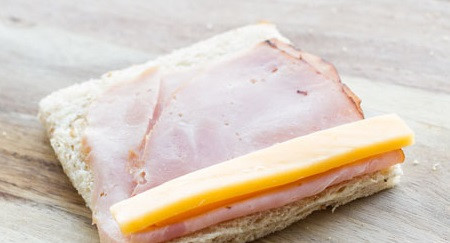 1. Этап. Рулетики с колбасой и сыром: 2. Хлеб можно смазать любимым соусом или обыкновенным майонезом, например. Сверху выложить тонкий ломтик колбасы или ветчины. Сыр нарезать небольшими брусочками и выложить сверху.