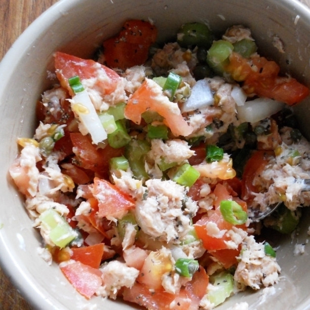 1. Этап. Салат из консервированной горбуши: Добавляем кубиками нарезанный сельдерей и помидор.