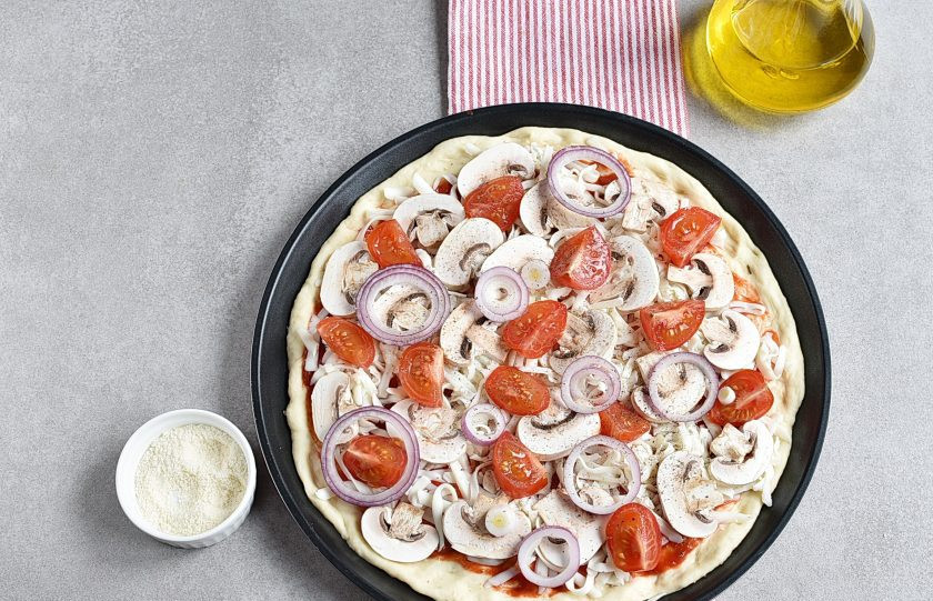 1. Этап. Пицца с шампиньонами: Выложите на сыр тонко нарезанные шампиньоны, нарезанные четвертинками помидоры и тонике колечки лука. Поперчите по вкусу. А вот солить не рекомендую – будет излишняя влага.