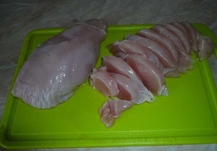 1. Этап. Кабачки, тушенные с курицей: Грудку промойте и нарежьте ломтиками средней величины.