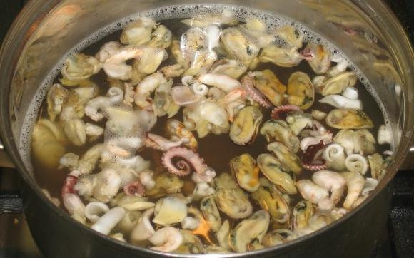 1. Этап. Сифудо тяхан: Вскипятите воду. Промойте морепродукты. Поместите их в кипяток и вновь доведите до кипения. Варите всё в течение 7 минут. Затем оставьте морепродукты в бульоне без огня на 15 минут. В это же время отварите рис.