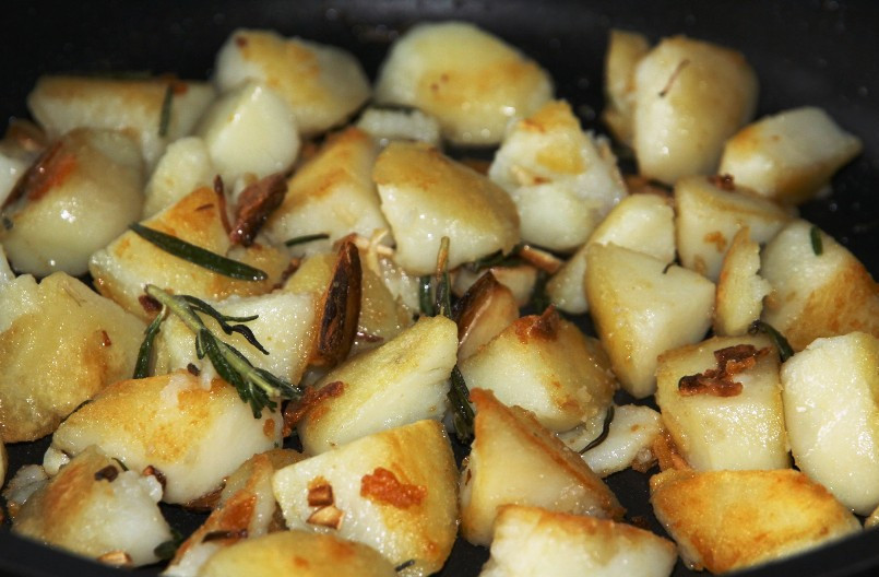 1. Этап. Жареный картофель с розмарином: Картофель порежьте крупными кусками и также отправьте на сковороду. Обжарьте на среднем огне до появления румяной корочки. В процесс не перемешивайте лопаточкой, а встряхивайте сковородку с содержимым. Это позволит сохранить кусочки картофеля целыми и не превратить блюдо в однородную массу. Готовую картошечку немедленно подавайте на стол.