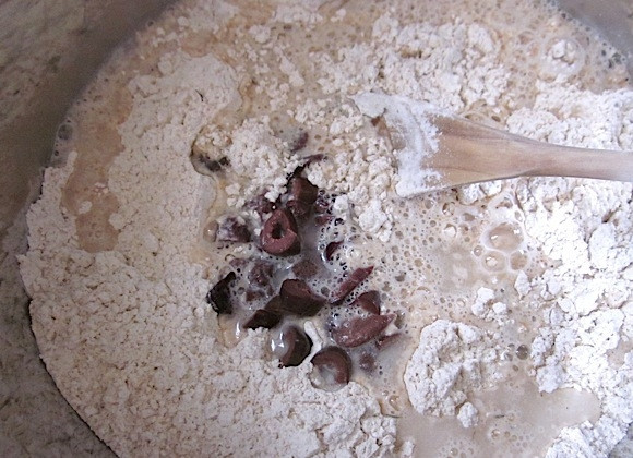 1. Этап. Хлеб с оливками: 3. Добавьте оливки в мучную смесь, влейте сперва 1 стакан воды, перемешайте.