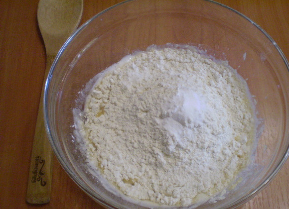 1. Этап. Выпечка из скисшего молока: Всыпьте муку, соду. Начните замешивать тесто.