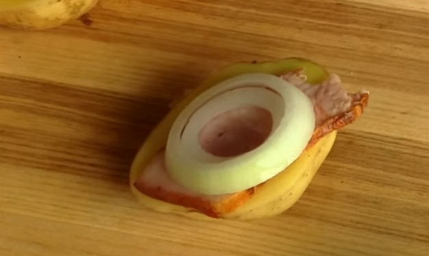 1. Этап. Картошка по-украински, запеченная в духовке: 4. На картошку выложите грудинку, затем — колечко лука, накройте второй половинкой картошки и зафиксируйте деревянной шпажкой.